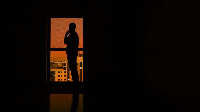 silhouette of woman standing in front of wall