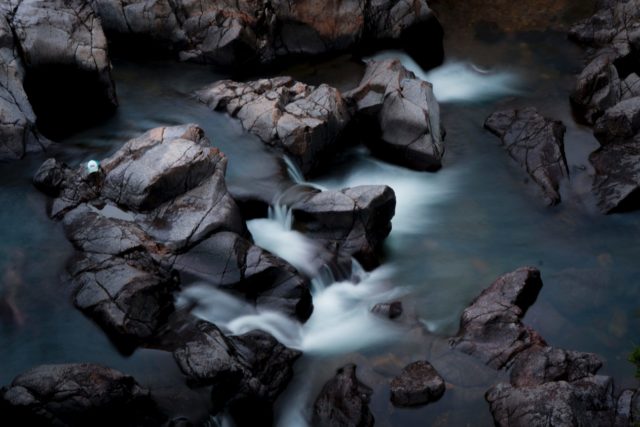 Photo par Intricate Explorer brown rocks on body of water