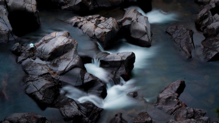 brown rocks on body of water