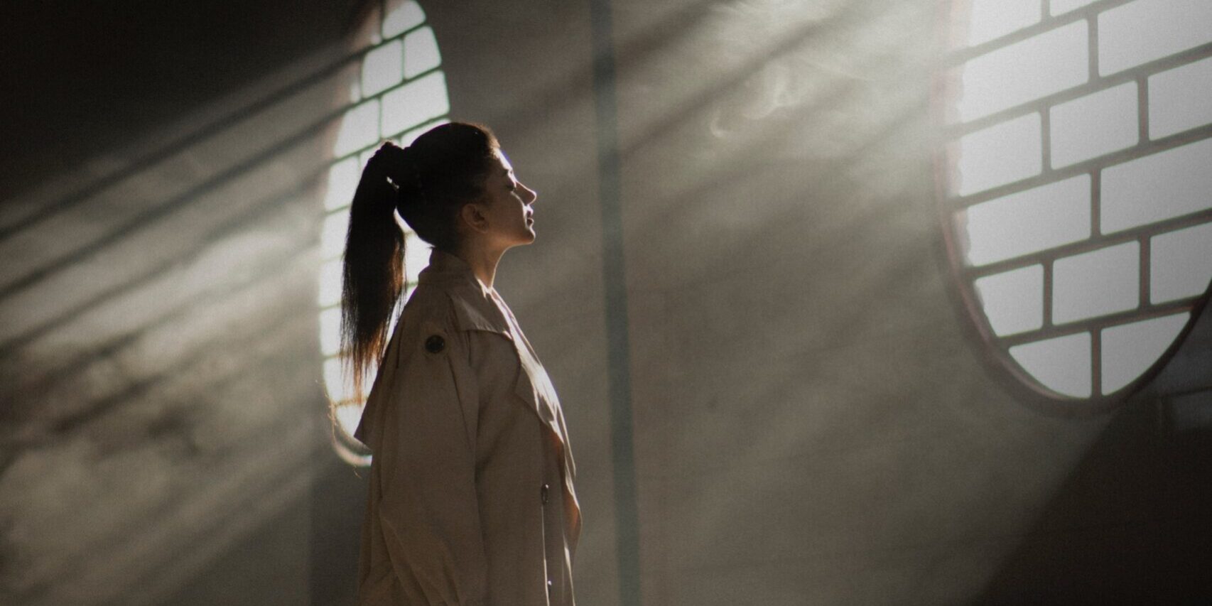 Photo par Ali Karimi woman in white coat standing in tunnel