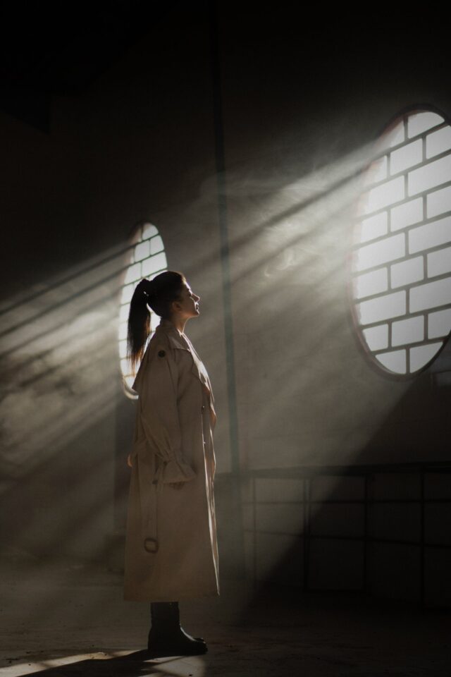 woman in white coat standing in tunnel