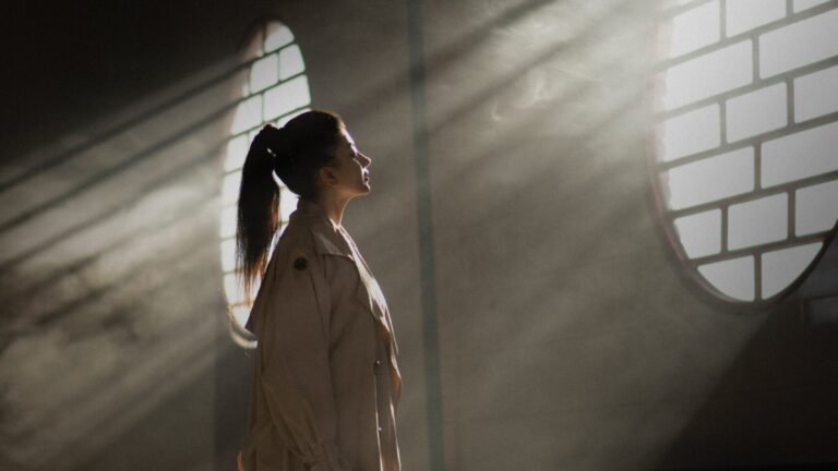 woman in white coat standing in tunnel